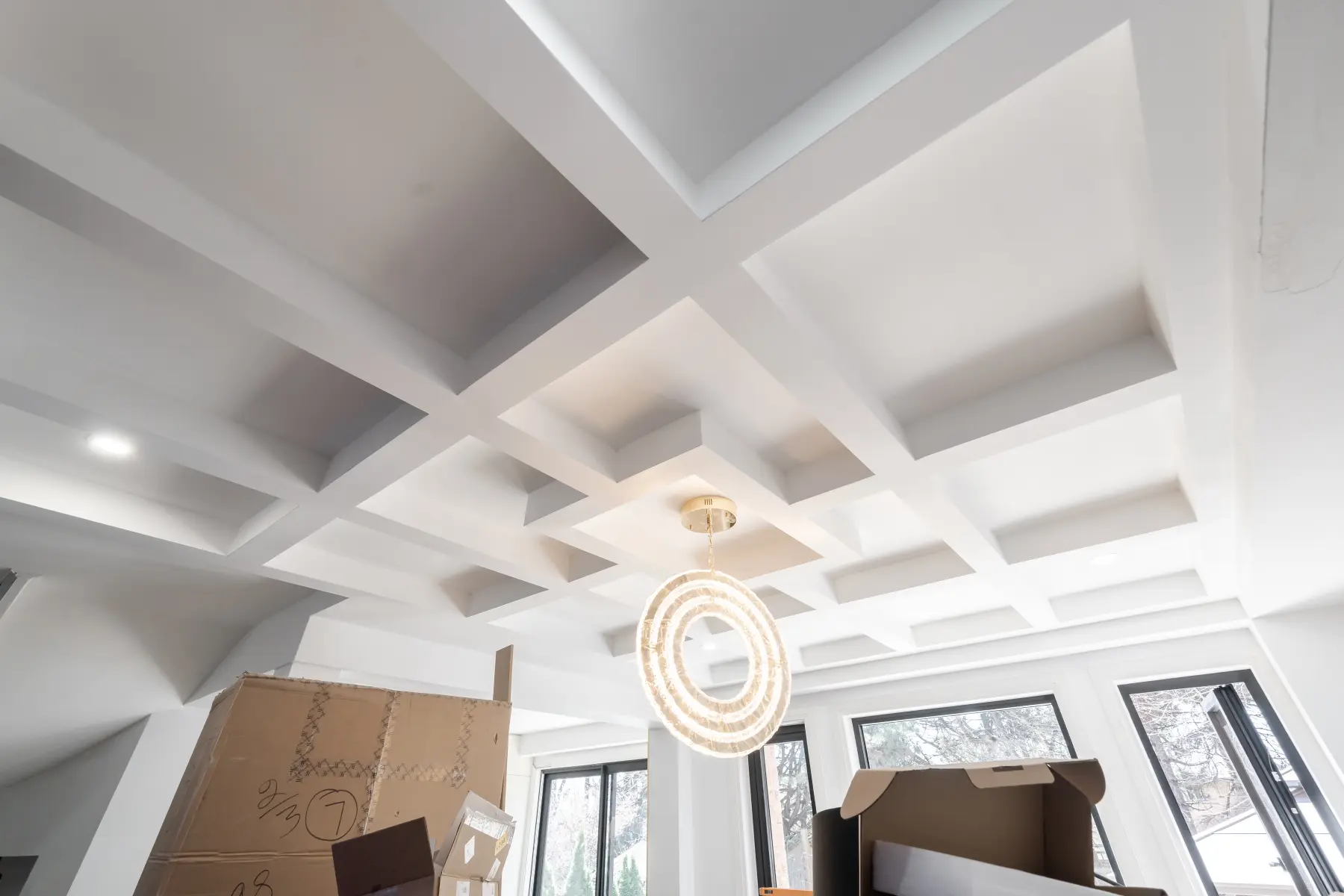 Custom coffered ceiling millwork with a pendant light