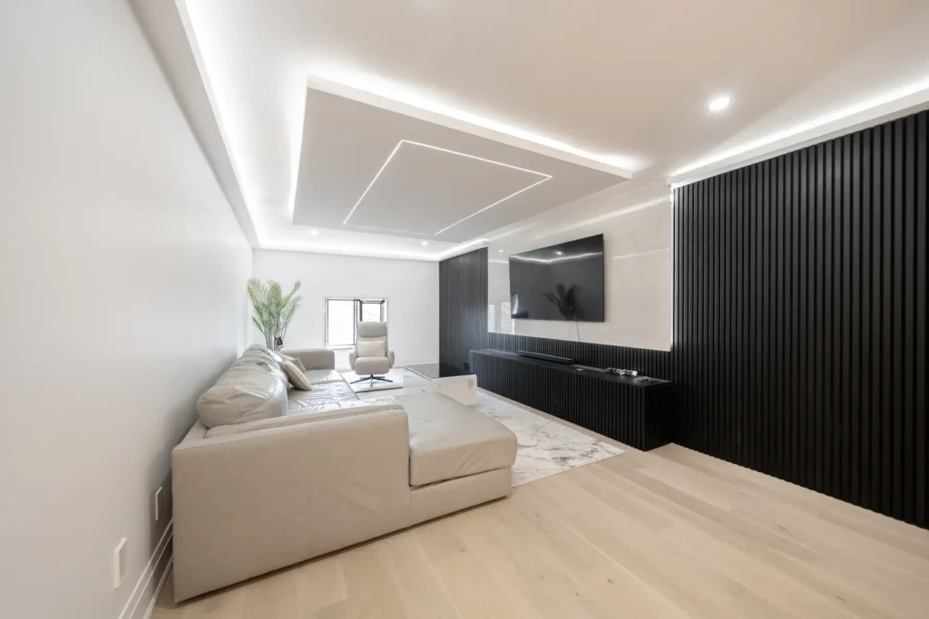 Living room with dark fluted wall panels and recessed ceiling lighting