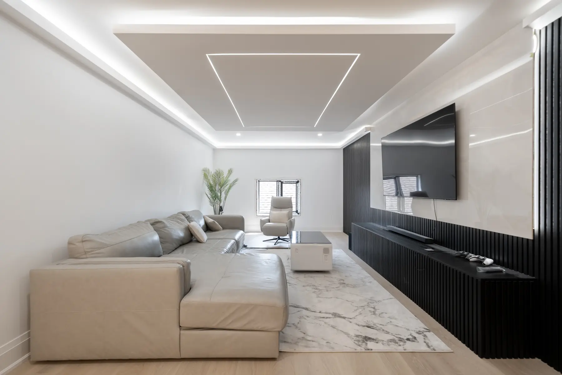 Contemporary living room with a dark fluted media wall and linear ceiling lighting