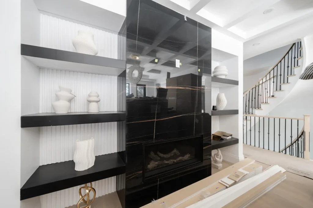 Fluted wall paneling and black floating shelves framing a fireplace