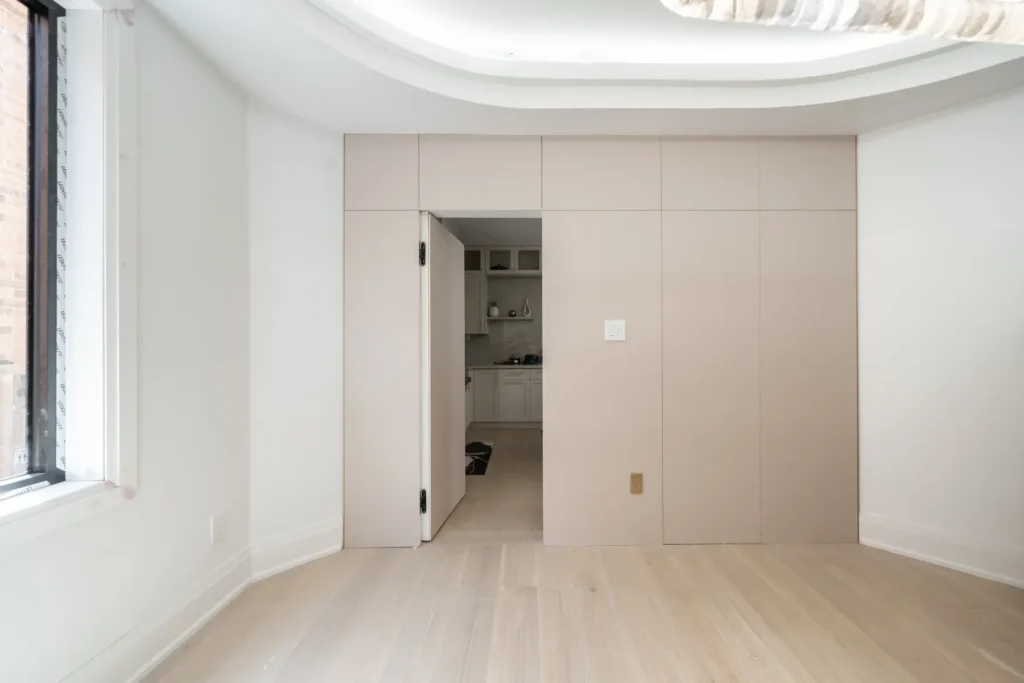 Hidden jib door concealed within contemporary flat-panel wall paneling